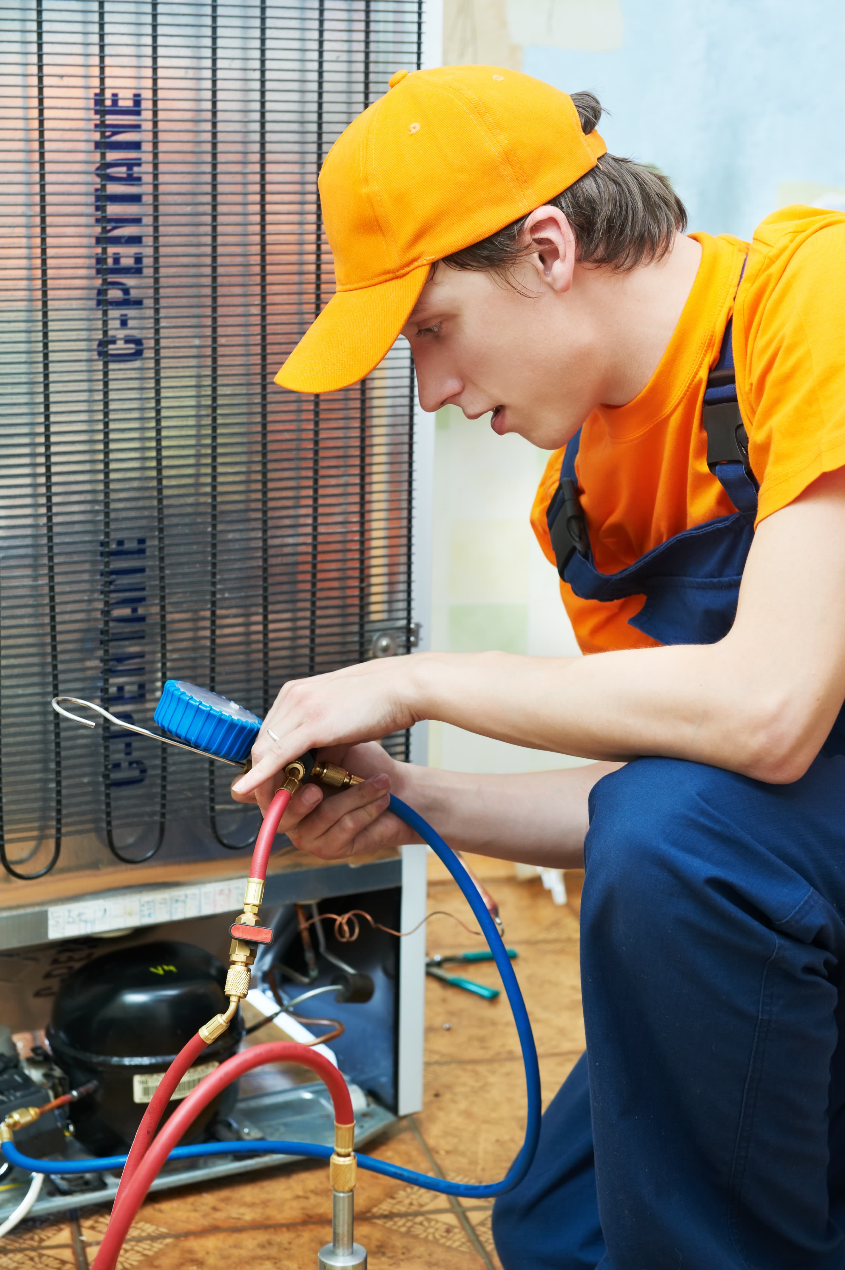 A Premium Refrigeration engineer repairing a commercial fridge